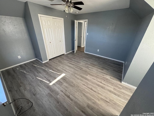 unfurnished bedroom with ceiling fan, a closet, and hardwood / wood-style floors