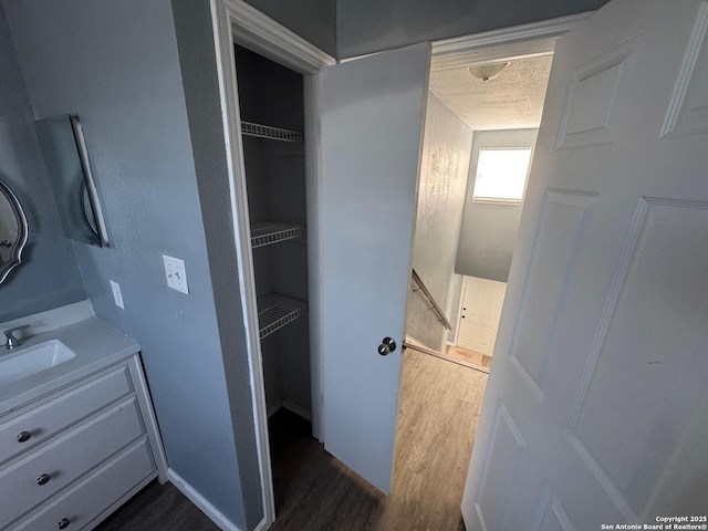 bathroom with hardwood / wood-style floors, vanity, and a textured ceiling