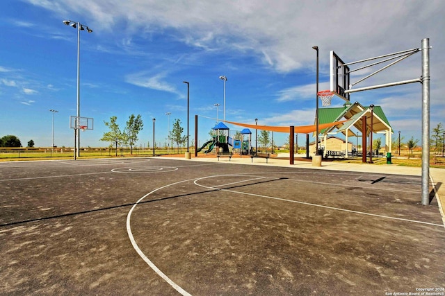 view of basketball court featuring a playground