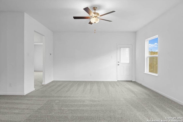 empty room with ceiling fan and light carpet