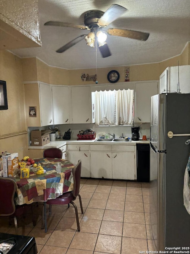 kitchen with dishwasher, white cabinets, sink, stainless steel fridge, and light tile patterned flooring