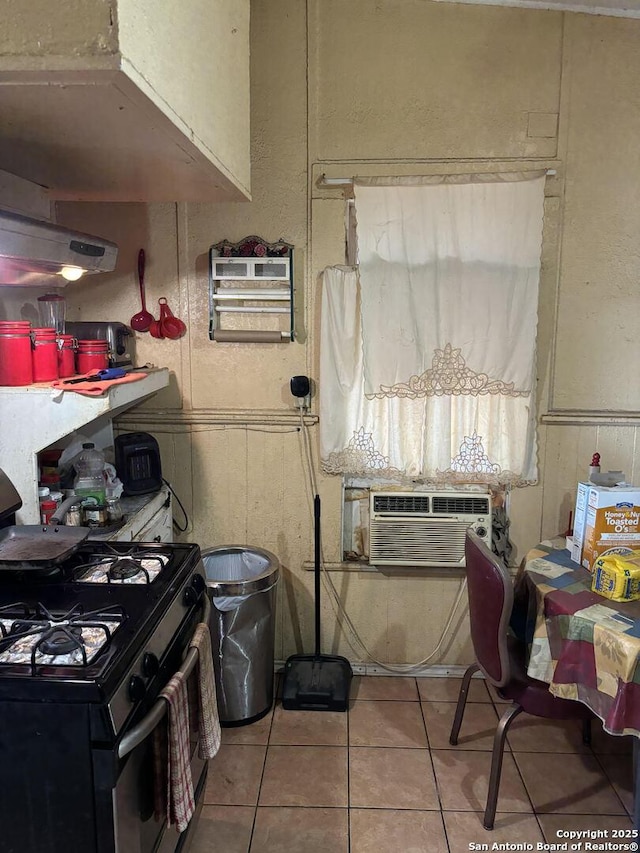 kitchen with light tile patterned flooring, black range with gas cooktop, and cooling unit