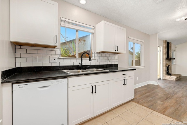 kitchen featuring a wealth of natural light, dishwasher, white cabinets, and sink