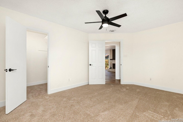 carpeted spare room featuring a textured ceiling and ceiling fan