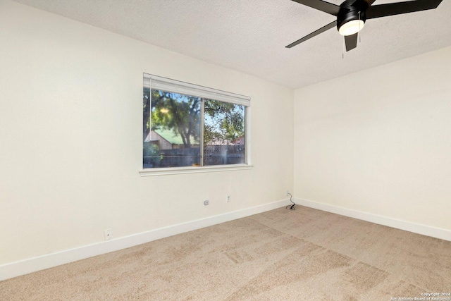 carpeted spare room featuring ceiling fan and a textured ceiling