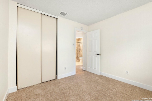 unfurnished bedroom featuring a closet and light colored carpet