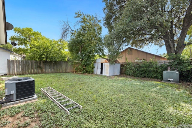 view of yard with central AC unit and a storage shed