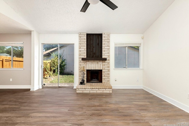 unfurnished living room featuring a textured ceiling, plenty of natural light, ceiling fan, and dark wood-type flooring