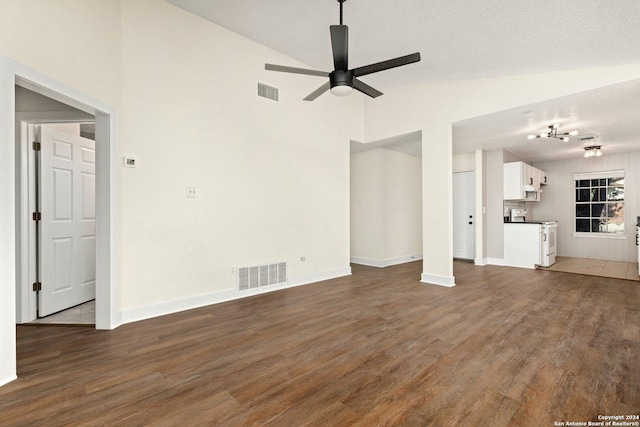 unfurnished living room with a textured ceiling, ceiling fan, dark hardwood / wood-style flooring, and vaulted ceiling