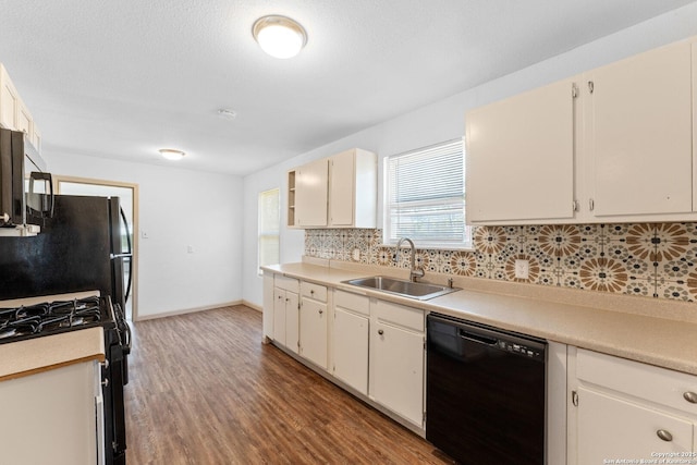 kitchen featuring white cabinetry, sink, hardwood / wood-style floors, decorative backsplash, and black appliances