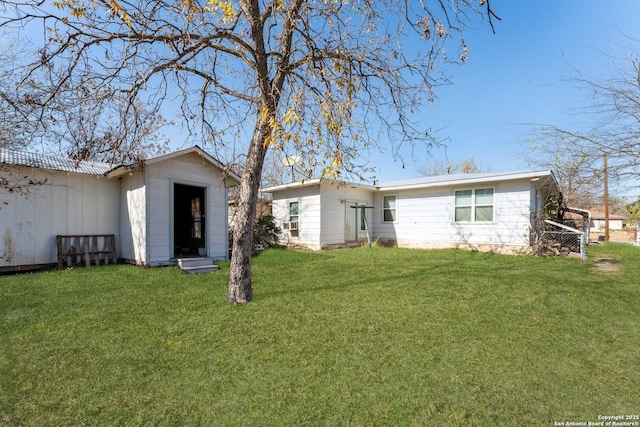 back of property with a yard and a shed