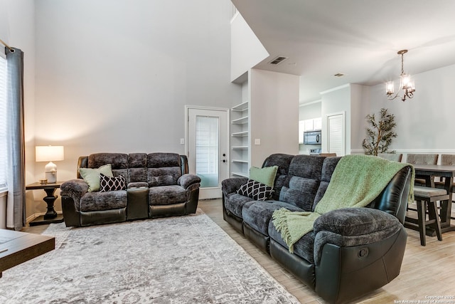 living room featuring a chandelier and light wood-type flooring