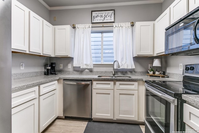 kitchen with sink, stainless steel appliances, light hardwood / wood-style flooring, white cabinets, and ornamental molding