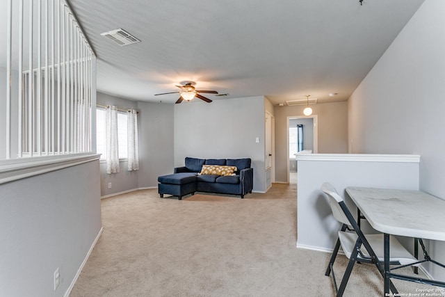 carpeted living room featuring a wealth of natural light and ceiling fan