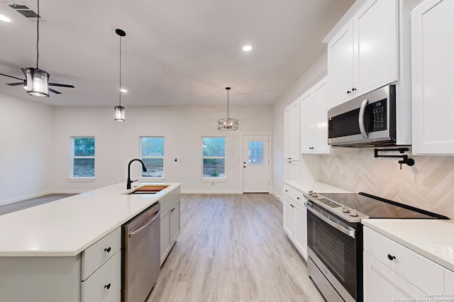 kitchen featuring sink, decorative backsplash, decorative light fixtures, white cabinetry, and stainless steel appliances