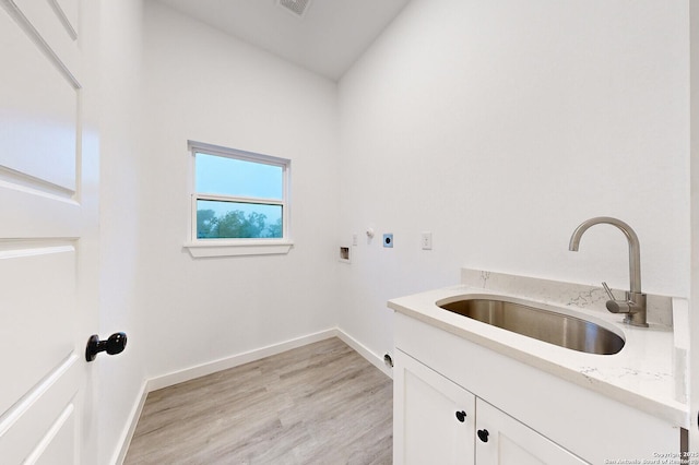 clothes washing area with hookup for an electric dryer, hookup for a washing machine, cabinets, sink, and light hardwood / wood-style flooring