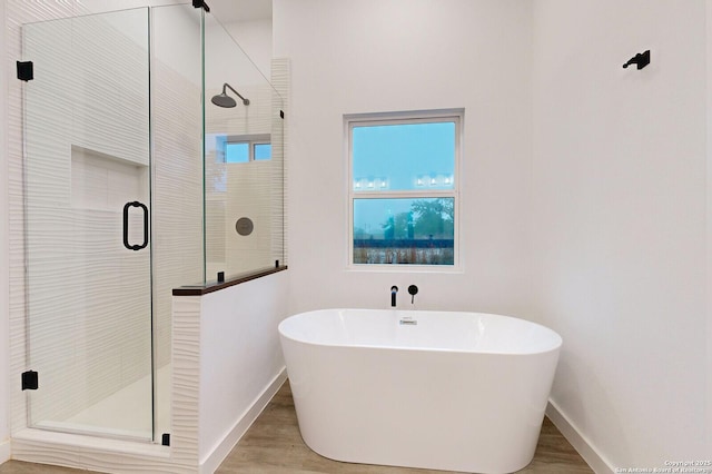 bathroom featuring hardwood / wood-style flooring and independent shower and bath