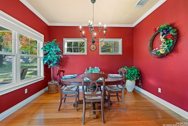 dining room featuring hardwood / wood-style flooring, crown molding, and a notable chandelier