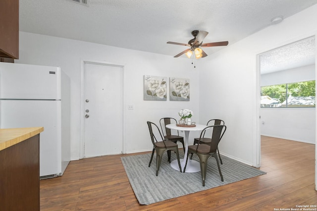 dining area featuring a textured ceiling, dark hardwood / wood-style flooring, and ceiling fan