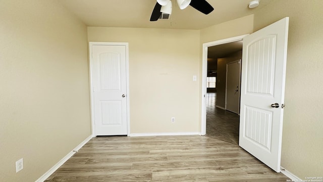 unfurnished bedroom featuring light wood-type flooring and ceiling fan