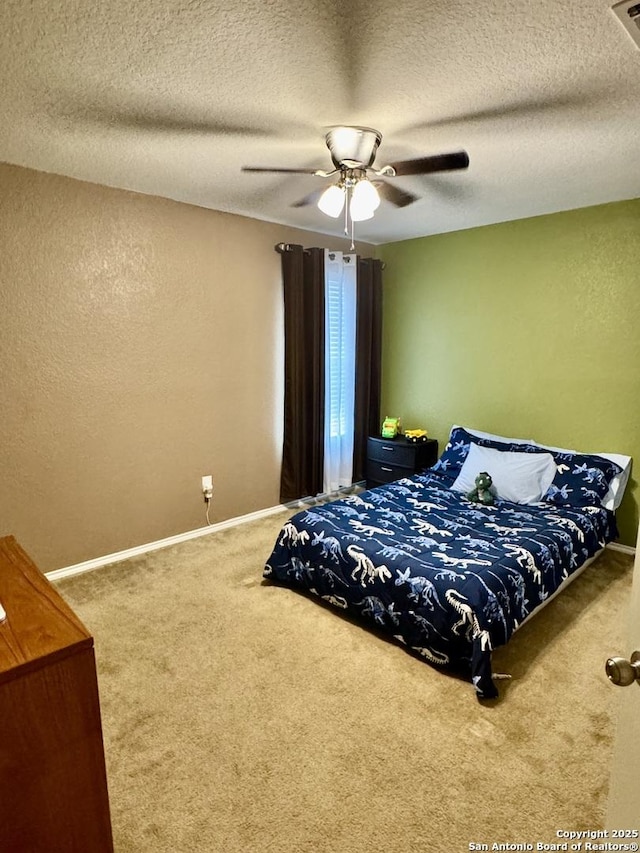 carpeted bedroom featuring ceiling fan and a textured ceiling