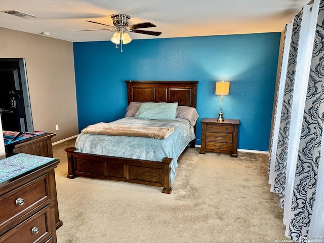 carpeted bedroom with ceiling fan and a textured ceiling