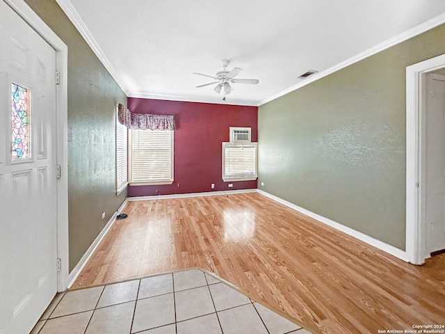 tiled empty room with ceiling fan and crown molding