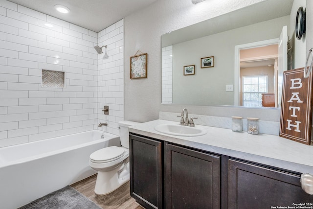 full bathroom with vanity, toilet, wood-type flooring, and tiled shower / bath