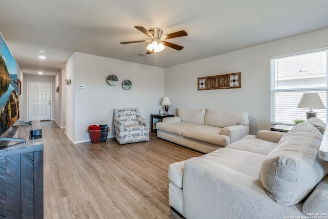 living room with hardwood / wood-style floors, a textured ceiling, and ceiling fan