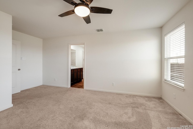 empty room with ceiling fan and light carpet