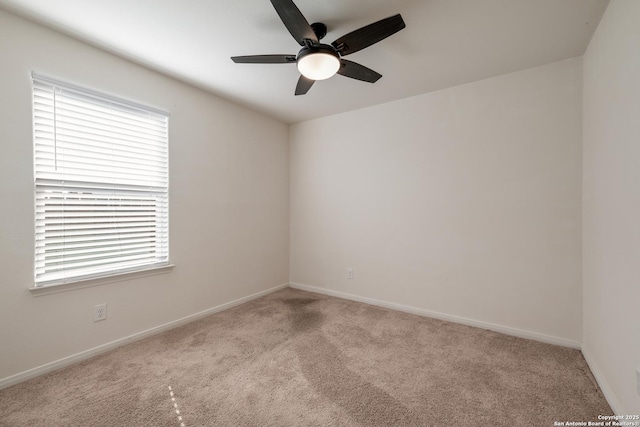 spare room with ceiling fan and light colored carpet