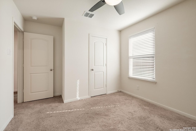 unfurnished bedroom with ceiling fan, a closet, and light carpet