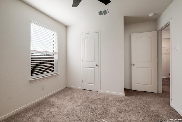 unfurnished bedroom featuring ceiling fan, a closet, and light colored carpet