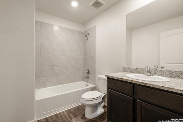 full bathroom featuring toilet, hardwood / wood-style floors, vanity, and tiled shower / bath