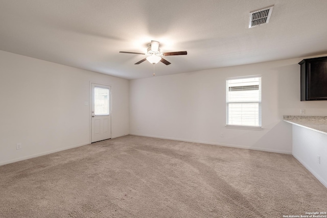 carpeted empty room featuring ceiling fan