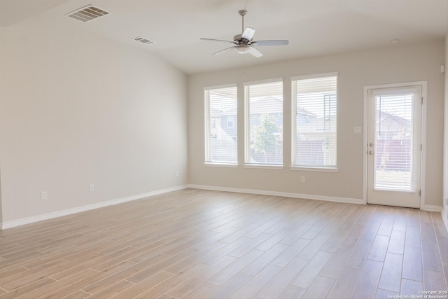 spare room featuring ceiling fan, lofted ceiling, and light wood-type flooring