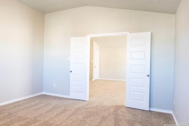 spare room with carpet and lofted ceiling