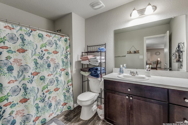 bathroom with hardwood / wood-style flooring, vanity, toilet, and a textured ceiling