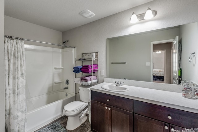 full bathroom featuring shower / bath combo, wood-type flooring, a textured ceiling, toilet, and vanity