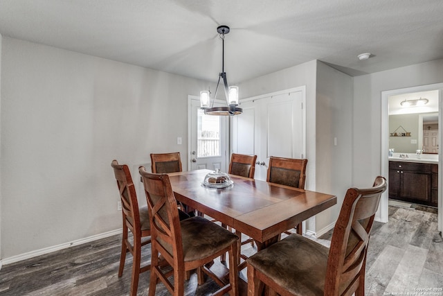 dining space with a chandelier and wood-type flooring