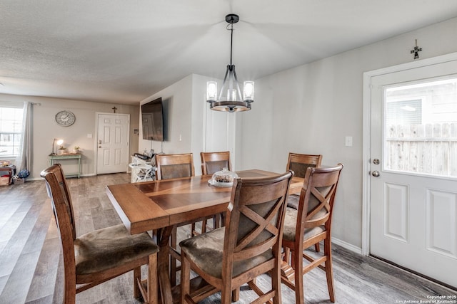 dining space featuring light hardwood / wood-style flooring and a notable chandelier