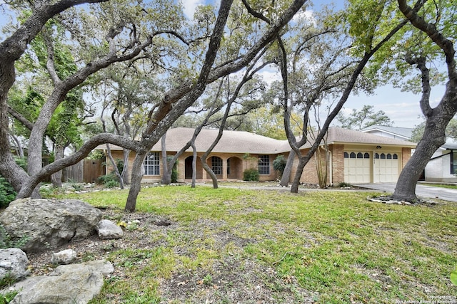 single story home featuring a garage and a front lawn