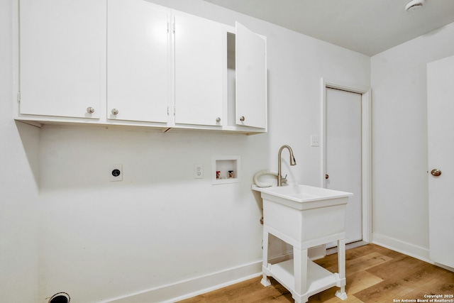 washroom with washer hookup, electric dryer hookup, cabinets, and light wood-type flooring