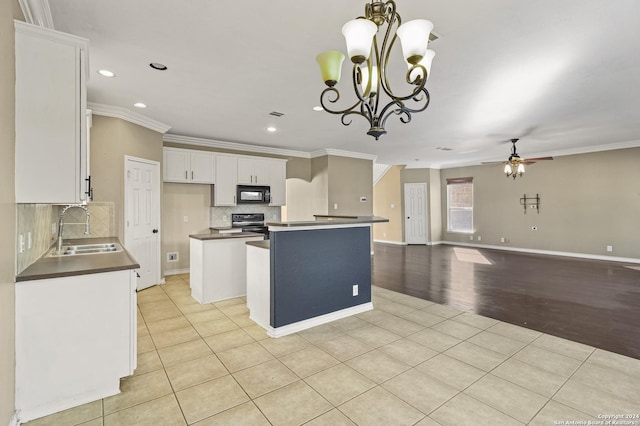 kitchen featuring ceiling fan with notable chandelier, a kitchen island, black appliances, sink, and white cabinetry