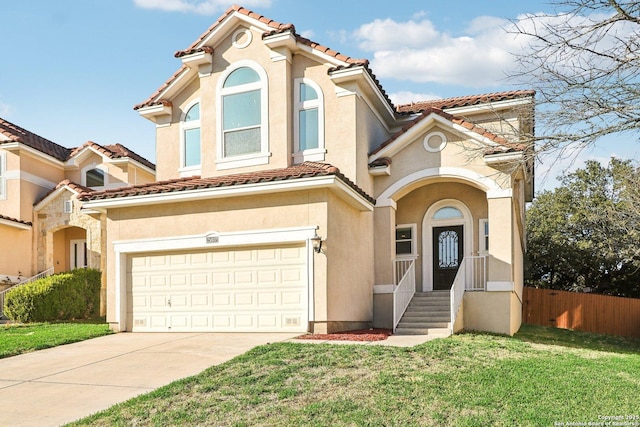 mediterranean / spanish home featuring a front yard and a garage