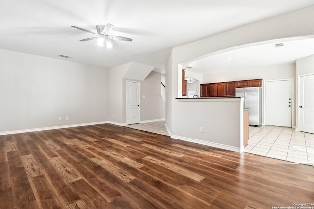 unfurnished living room featuring ceiling fan and wood-type flooring