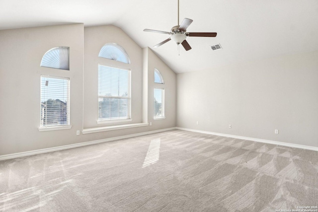 carpeted empty room featuring ceiling fan, plenty of natural light, and high vaulted ceiling