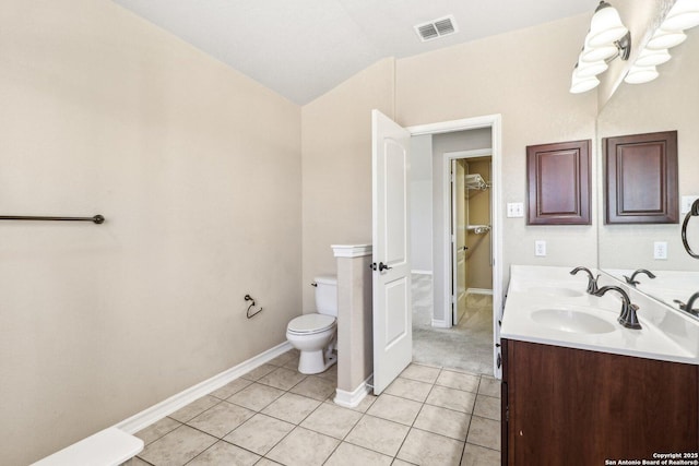 bathroom featuring tile patterned floors, vanity, toilet, and vaulted ceiling