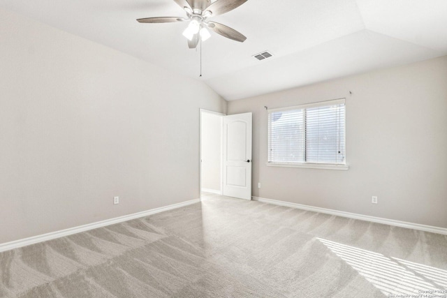 spare room featuring ceiling fan, lofted ceiling, and light carpet