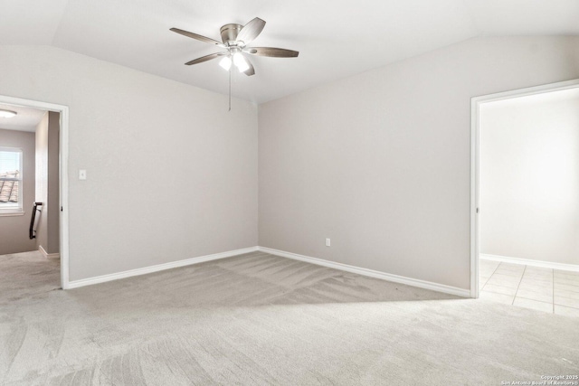 empty room with light colored carpet, vaulted ceiling, and ceiling fan